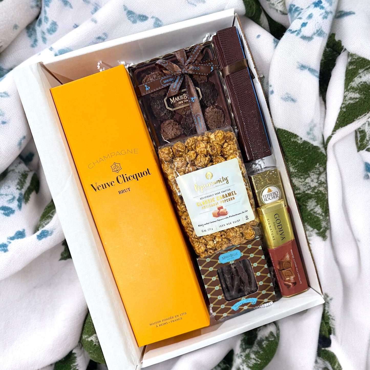 Gift box with Veuve Clicquot champagne, chocolate, and popcorn.