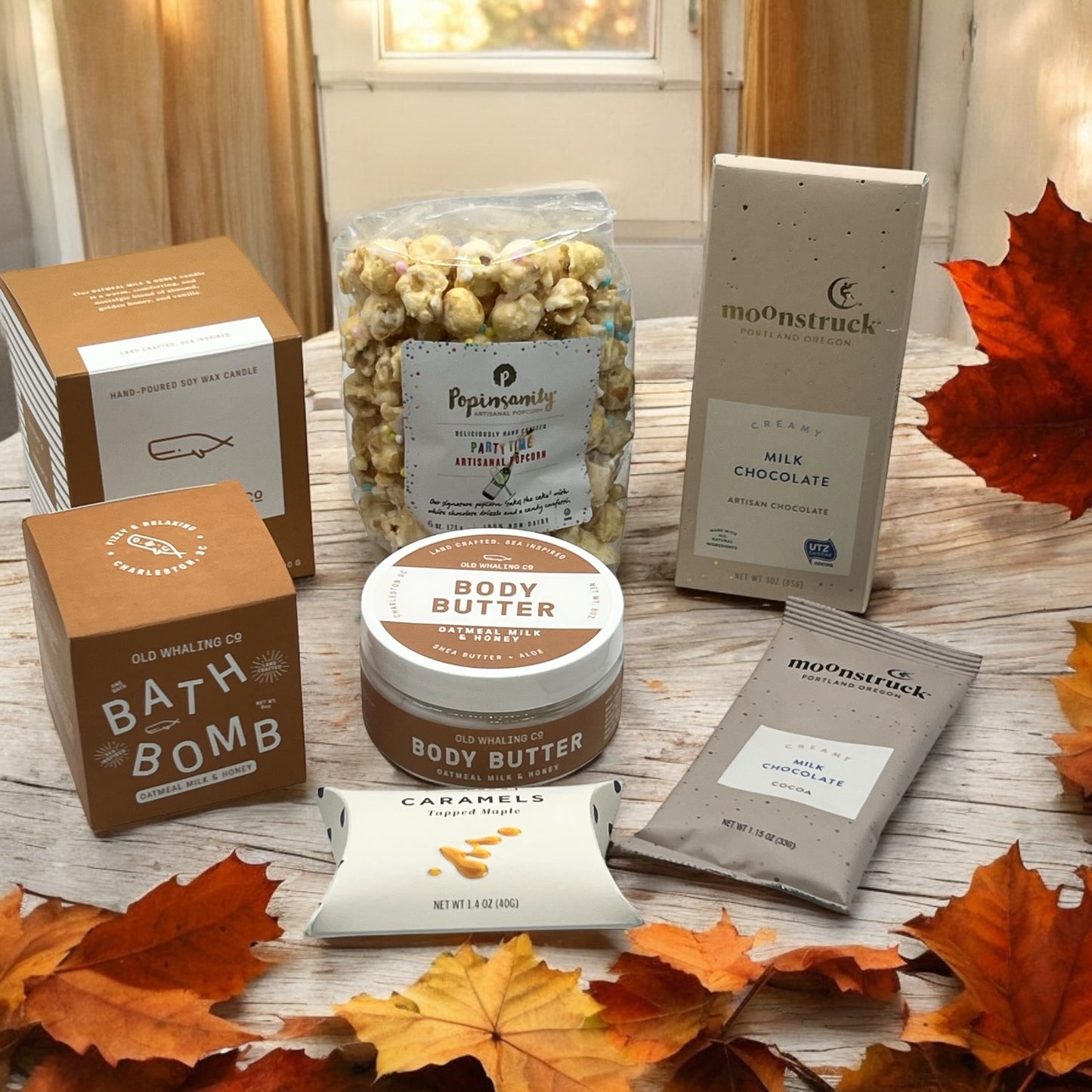 Gourmet gift box containing oatmeal spa products, gourmet popcorn, artisan chocolates, caramels, and hot cocoa.