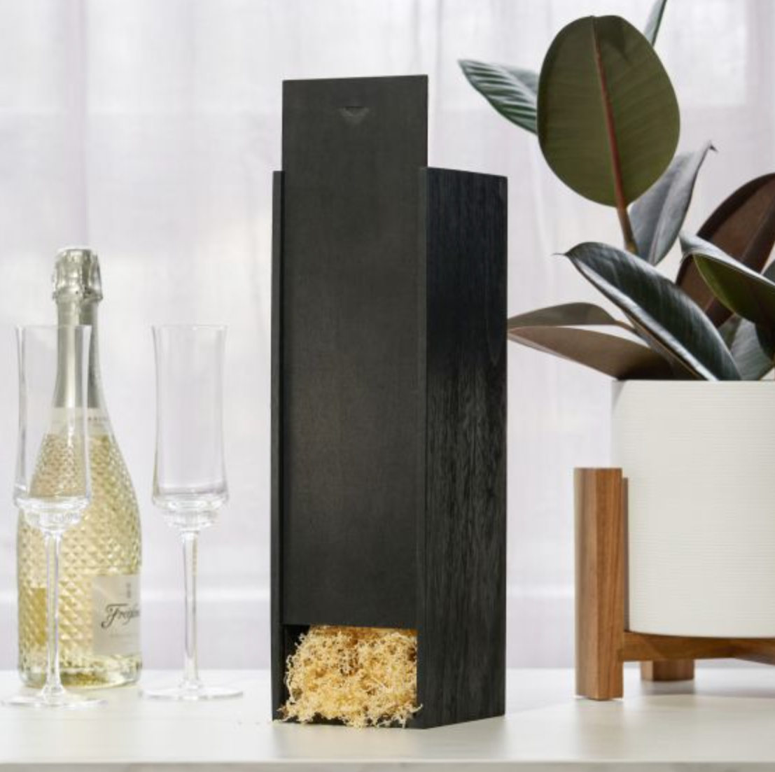 Veuve Clicquot Champagne tucked inside black wood crate.