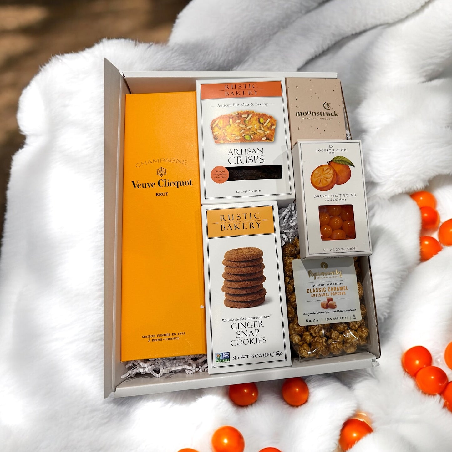 Gift box with Veuve Clicquot champagne, Rustic Bakery cookies, and other snacks.