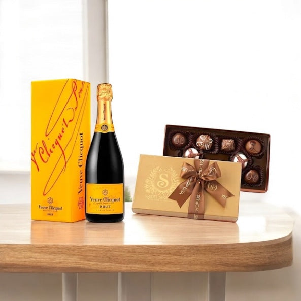 Artisan chocolates with intricate designs beside a bottle of Veuve Clicquot Champagne