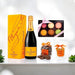 Gift box containing Veuve Clicquot Champagne and pastel macarons, chocolate pretzels and popcorn.
