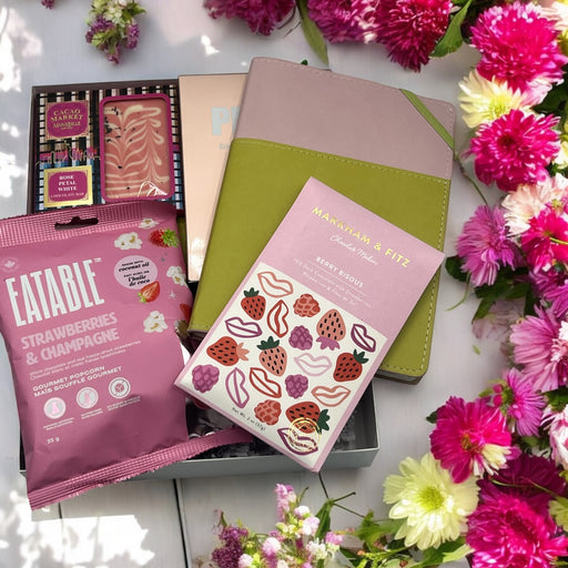 Gourmet gift basket with popcorn, artisan chocolates, and a vegan leather journal, perfect for all occasions including Mother's Day.