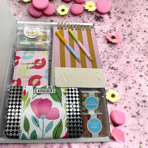 Gift box containing note pad, pens, floral macarons & cookies, sugarfina candies & strawbery cake bar.