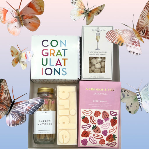 Congrats box filled with artisan chocolate bar, bride candle & matches, champagne candies and congrats cookies.