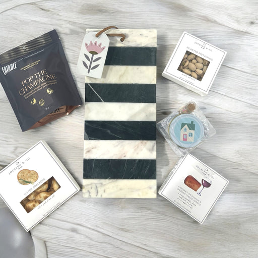 Housewarming gift includes marble cutting board with cheese, crackers, nuts, popcorn and house candle. Ships nationwide from NY.
