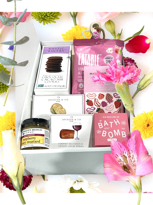 Gourmet snack gift box filled with cookies, popcorn, artisan chocolates, cheese, crackers, jam and bath bomb.