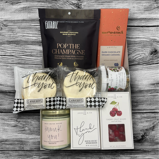 Thank you gift box filled cookies, crackers, candle, nuts, candy, popcorn, and artisan chocolates.